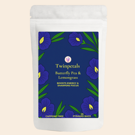 Front packaging of Twinpetals Butterfly Pea & Lemongrass Tea – a caffeine-free herbal tea blend that boosts energy and sharpens focus with vibrant purple flowers on a deep blue label