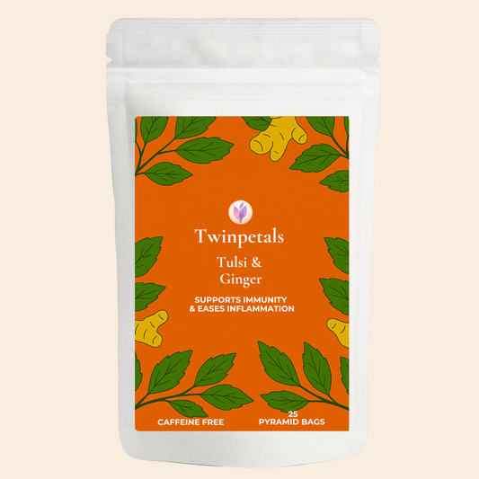 Front packaging of Twinpetals Tulsi & Ginger Tea – a caffeine-free herbal infusion that supports immunity and eases inflammation, with bold ginger and tulsi illustrations on an orange label